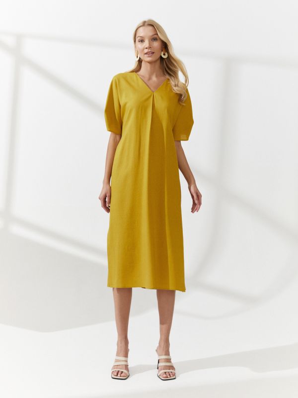 Mustard colored midi length dress with slits on the sides